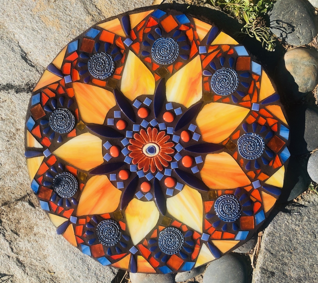 A colorful decorative plate sitting on the ground.