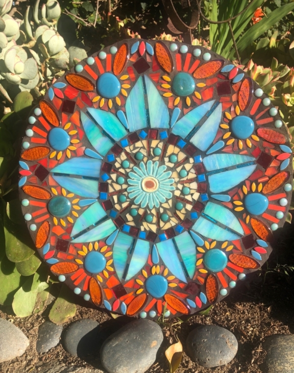 A colorful mandala sitting on top of a flower bed.