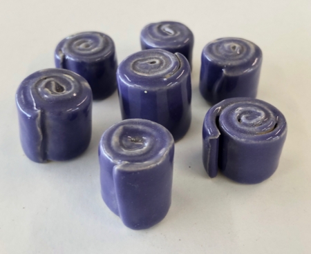 A group of seven rolls of purple wax.