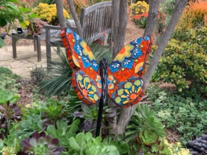 A colorful butterfly is standing on the ground.