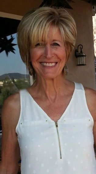 A woman in white shirt smiling for the camera.