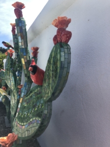 A cactus with red flowers and green leaves.