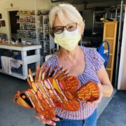 A woman holding an orange fish in her hands.