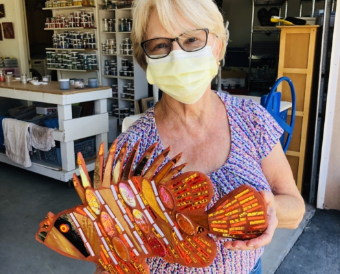 A woman holding an orange fish in her hands.