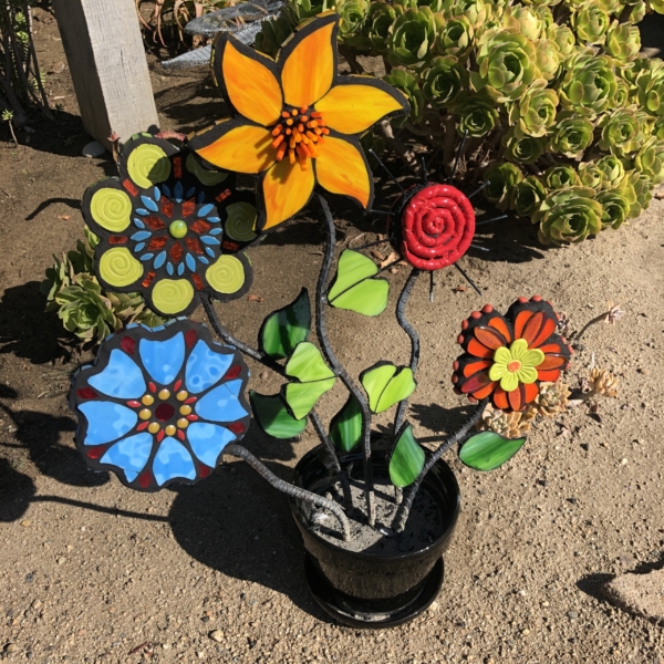 A potted plant with many different colored flowers.