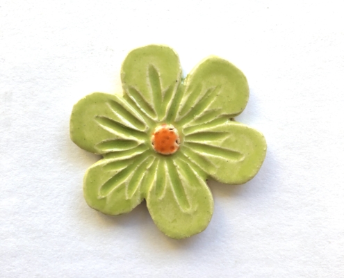 A green flower with orange center on white background.